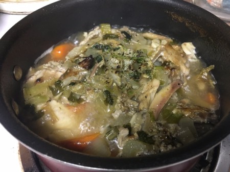 chopped vegetables and chicken parts in pan