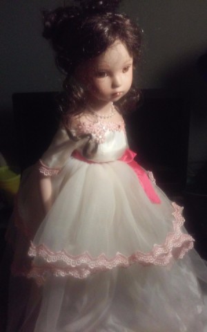 Identifying a Porcelain Doll - doll wearing a white dress with pink trim