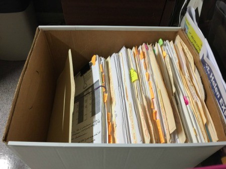 A disorganized box with manila file folders.