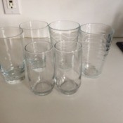 A collection of mismatched glasses on a countertop.