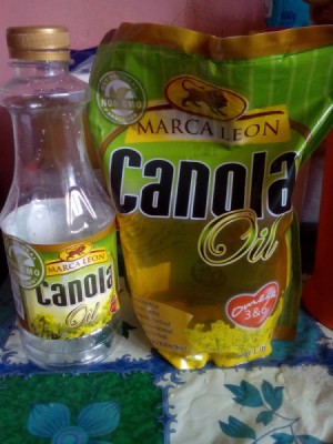 A bottle of canola oil next to a refill pack.