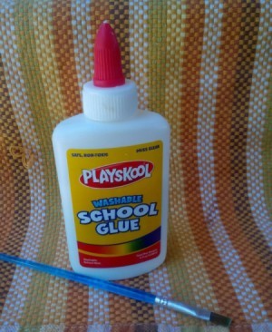 A bottle of white school glue and a paintbrush.