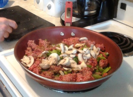 ground beef, mushrooms and green peppers in skillet