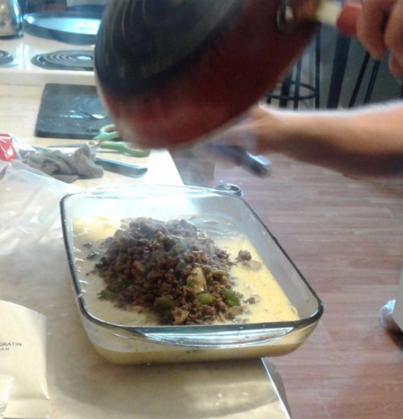 cooked Ground Beef poured on Scalloped Potatoes