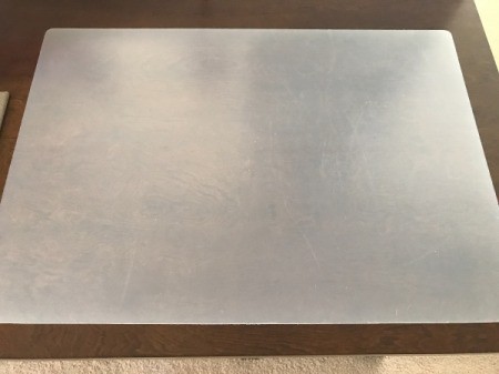 A large desk mat protecting a wooden desk.