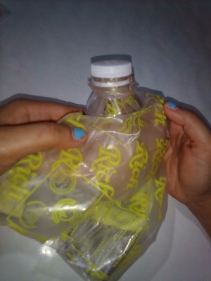 A makeshift closure to a plastic bag, using a bottle top and cap.