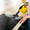 Woman Cleaning stove with Steam Cleaner
