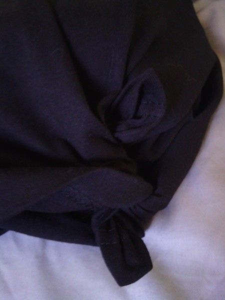 Tying the t-shirt corners together behind the pillow.