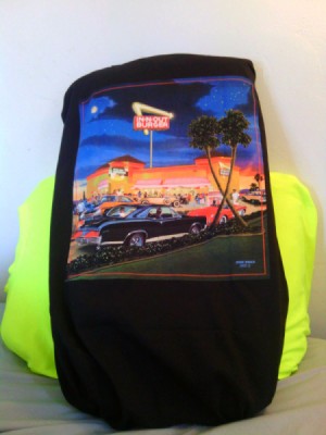 An In-N-Out Burger T-Shirt placed over a pillow, with a second bright yellow T_Shirt pillow behind.