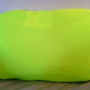 A bright yellow green T-shirt covering a pillow.