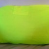 A bright yellow green T-shirt covering a pillow.