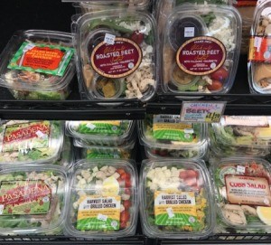 An assortment of different prepackaged salads in a supermarket.