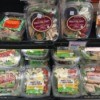 An assortment of different prepackaged salads in a supermarket.