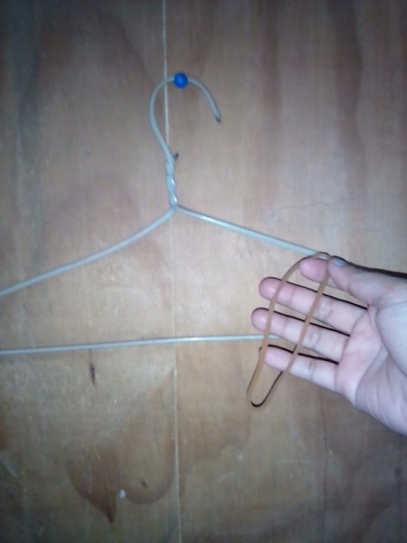 Placing a rubber band on a clothing hanger.