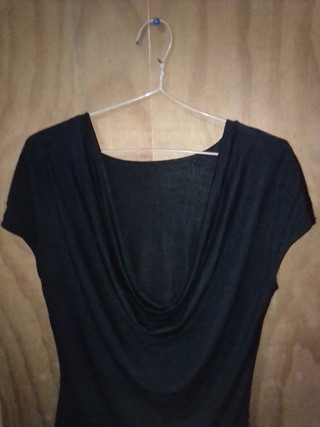 A black top hung on a clothes hangar with rubber bands.