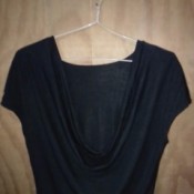 A black top hung on a clothes hangar with rubber bands.