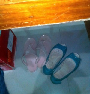 Two pairs of shoes under a worktable.