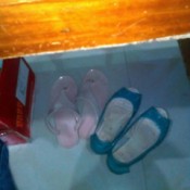 Two pairs of shoes under a worktable.