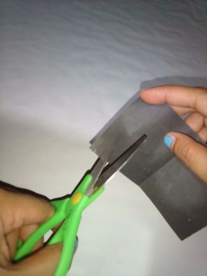 Scissors cutting through sandpaper to sharpen them.