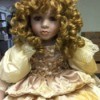 Value of Porcelain Dolls - doll with very curly hair wearing an ecru dress