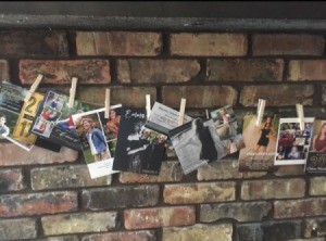 A line of graduation announcement and invites, hanging from a mantle.