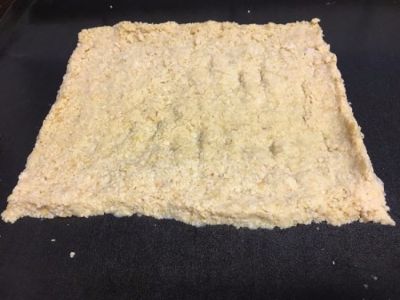 Flourless Chicken Pizza Crust spread on baking sheet