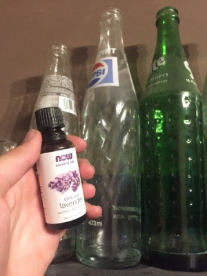 A bottle of essential oil near collectible glass bottles.