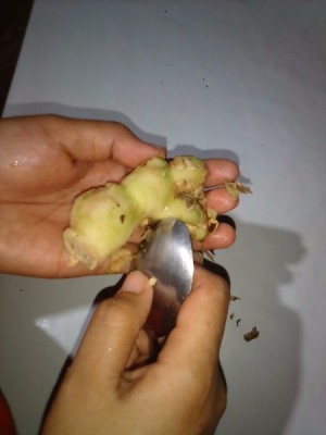 Peeling a ginger root with a spoon.