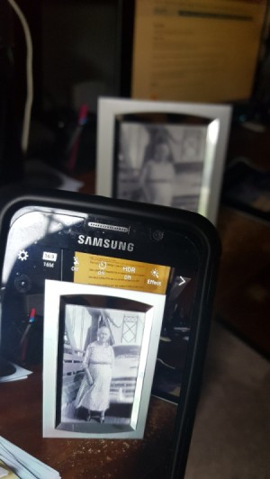 Taking a photo of an old silver picture frame with a smartphone.