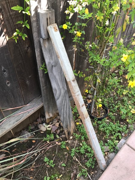 Wooden supports to keep a leaning fence upright.