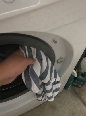 Wiping down the gasket in a washing machine door.