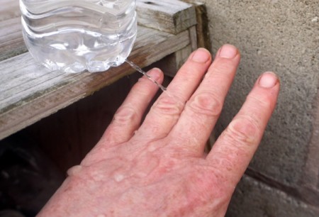 DIY Outdoor Plastic Bottle Handwashing Station - rinsing back of hand