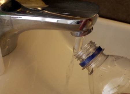 DIY Outdoor Plastic Bottle Handwashing Station - filling bottle
