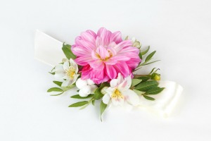 A pink and white wrist corsage.