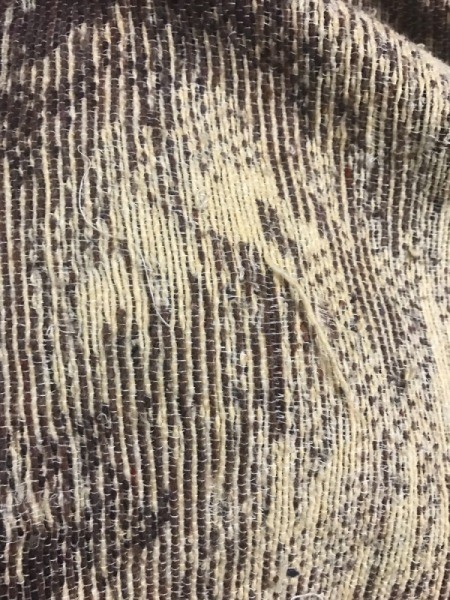 A close up of a worn woven blanket.