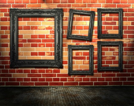 Picture frames hanging on brick.