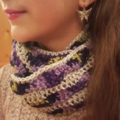 A crocheted cowl infinity scarf with a wave pattern.