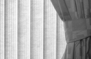 A window treatment of vertical blinds and curtains.