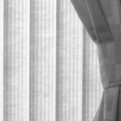 A window treatment of vertical blinds and curtains.