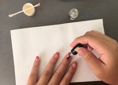 Putting a top coat over the finished French tips.