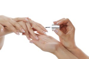 Applying nail polish to fingernails.