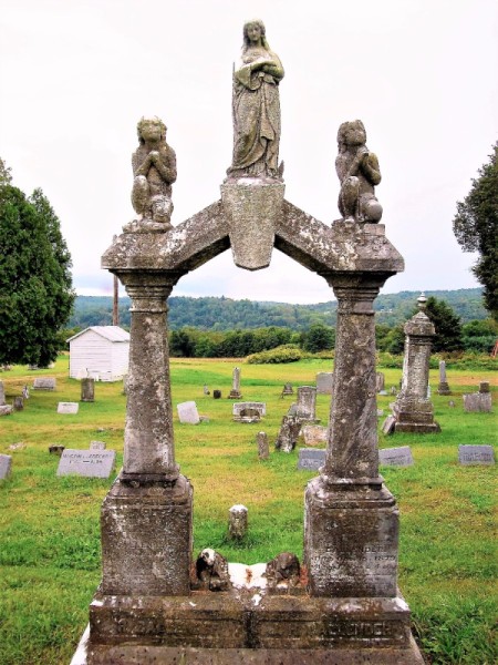 Gravestone Frames a Living Picture - gravestone arch with view of scenery through it