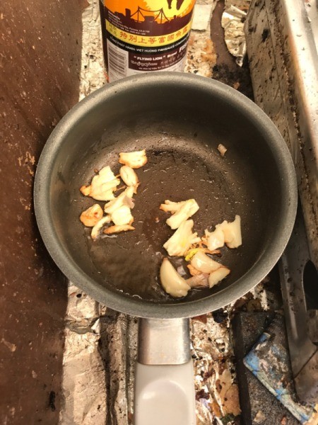 sliced garlic cooking in pan