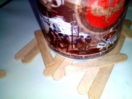Mug Holder with Goody Compartment - Arrange cut halves of Popsicle sticks around the mug. Glue into place.