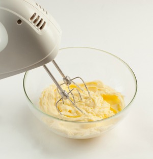Using a hand mixer to whip store bought frosting.