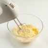 Using a hand mixer to whip store bought frosting.