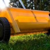 A yellow lawn fertilizer broadcast spreader.