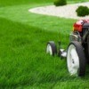 A lawn mower in the process of mowing a lush green lawn.