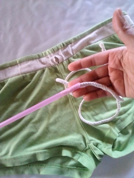 Placing a drinking straw as a channel for draw cords in clothing.
