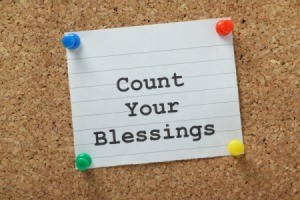 A note card on a bulletin board that says count your blessing on it.